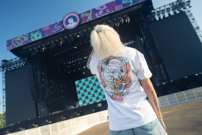 Vrouw met wit shirt aan met gekleurde tattoo opdruk op rug
